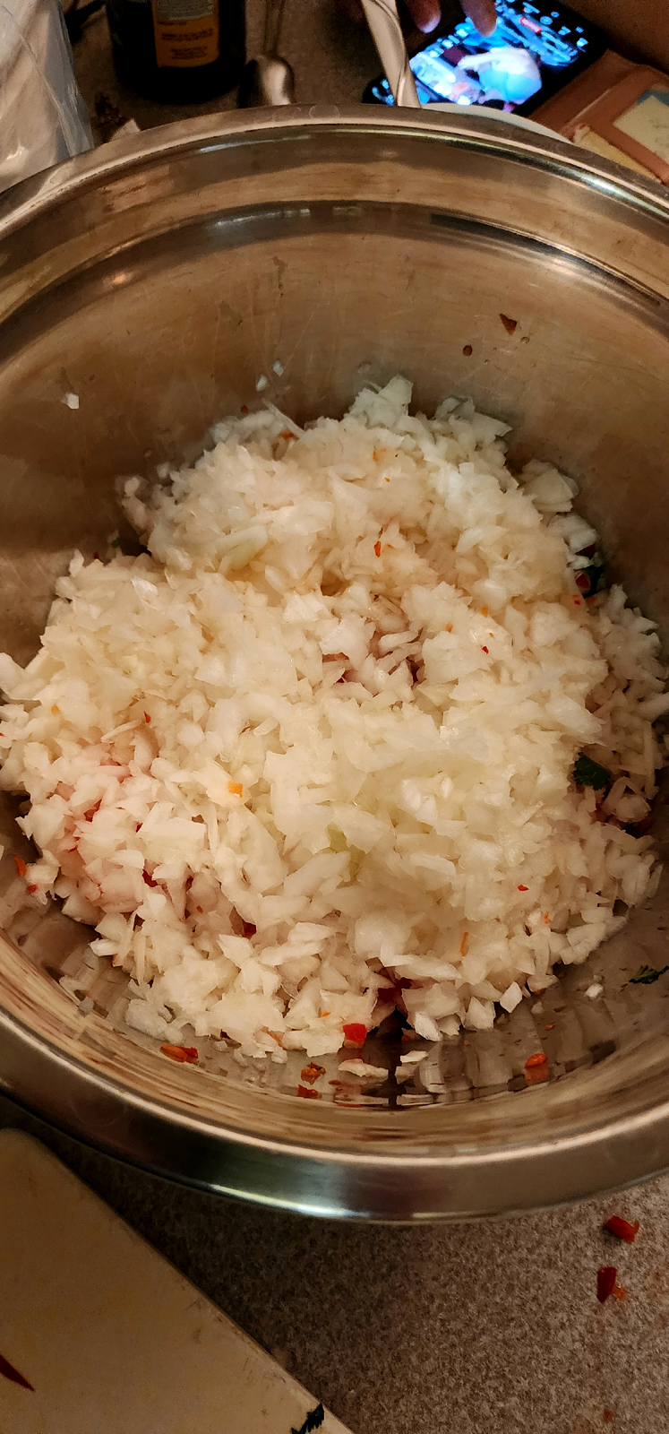 Mixing bowl with diced cilantro, red bell pepper and onions